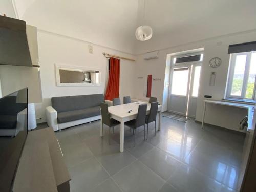 ein Wohnzimmer mit einem Tisch und einem Sofa in der Unterkunft Nicola’s house in Procida