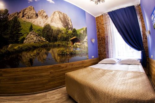 a bedroom with a mountain mural on the wall at Bonjour Hotel in Saint Petersburg