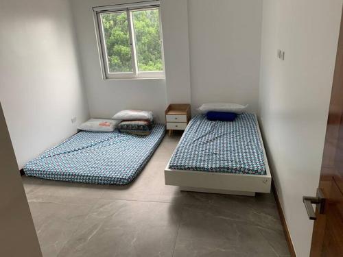 2 Betten in einem Zimmer mit Fenster in der Unterkunft Mansion house in Antipolo