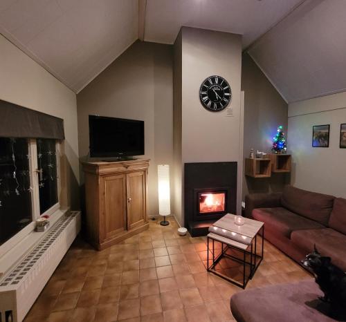 a living room with a couch and a fireplace at Vakantiehuis 6 pers, Oostduinkerke aan zee in Koksijde