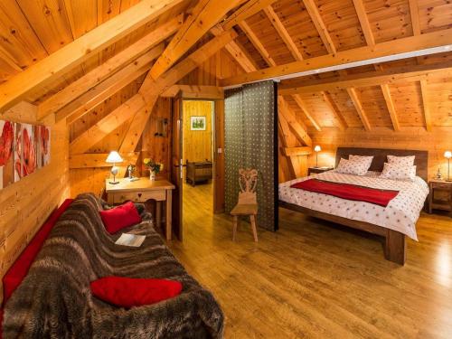 a bedroom with a bed and a couch in a room at Chalet cosy 6 pers avec SPA, terrasse sud, proche station ski, animaux admis - FR-1-393-16 in Saint-Michel-de-Chaillol