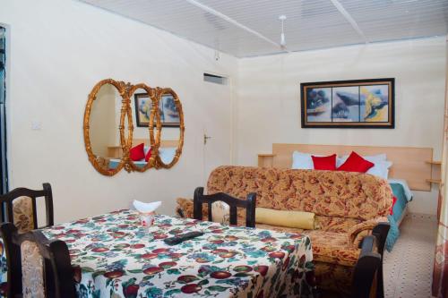ein Esszimmer mit einem Tisch und einem Sofa in der Unterkunft THE PLANTAINS PLACE in Karatina
