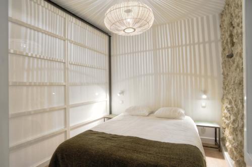 リスボンにあるBmyGuest - Castelo Charming Flatのベッドルーム1室(ベッド1台、シャンデリア付)