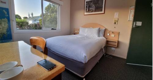 a hotel room with a bed and a desk and a table at The Dannebrog Lodge in Devonport