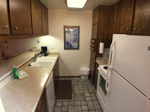a kitchen with a white refrigerator and a sink at 102 Standard Condo in Mammoth Lakes