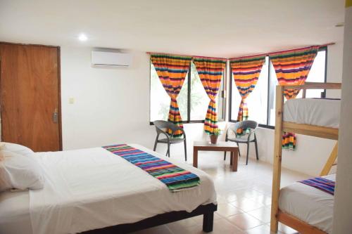 1 dormitorio con 2 camas y 1 litera en Hostal Casa Bohemia, en Mérida