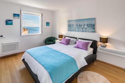 a bedroom with a large bed with purple pillows and a window at Marina Lux Split in Split