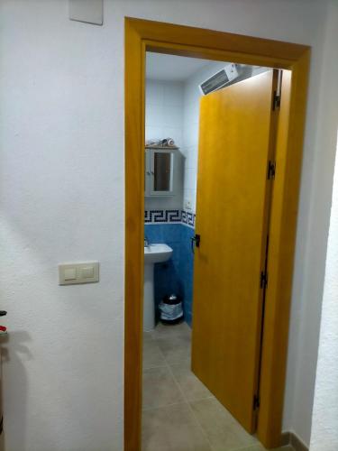 a door leading to a bathroom with a sink at Casa Rural Ardwina II in Alía