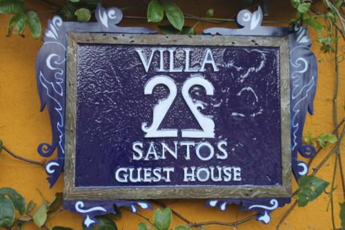 un panneau indiquant la maison d'hôtes Villa santa claus dans l'établissement Guest House Villa 2 Santos, à Arraial d'Ajuda