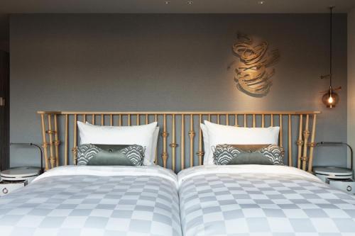 two beds sitting next to each other in a bedroom at Mercure Kyoto Station in Kyoto