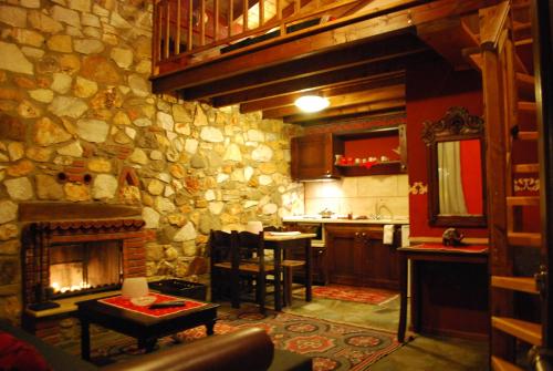 a kitchen with a stone wall with a fireplace at Tzivaeri in Likodhrómion