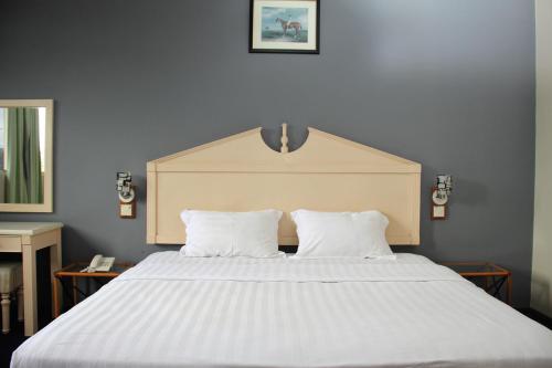 a large white bed with two pillows in a bedroom at Sandakan Inn in Sandakan