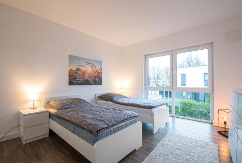 1 dormitorio con 2 camas y ventana en 150qm Haus mit 4 Schlafzimmern, Sauna, Parkplatz, en Lüneburg