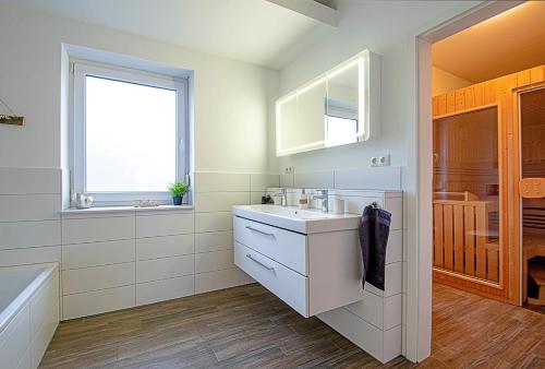 a bathroom with a sink and a tub and a window at 150qm Haus mit 4 Schlafzimmern, Sauna, Parkplatz in Lüneburg