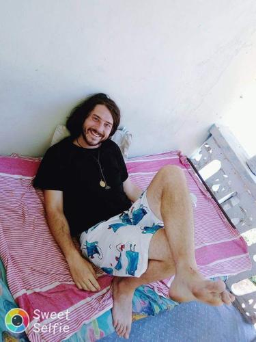 a man is sitting on a bed at HOME HOSTEL ELLA private rooms only in Ella
