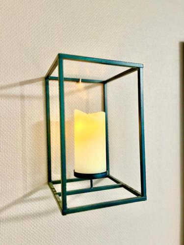 a light with a glass frame hanging on a wall at L'atelier Chic - Wifi fibre - Parking privée - Balcon - NETFLIX in Lanester
