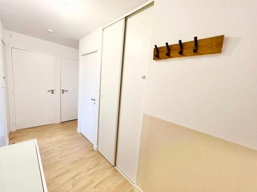 a room with a white closet with a knife on the wall at L'atelier Chic - Wifi fibre - Parking privée - Balcon - NETFLIX in Lanester