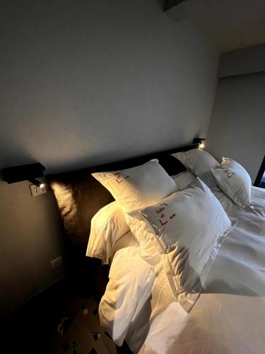 a bed with white sheets and pillows in a room at Suite 28 in Treilles