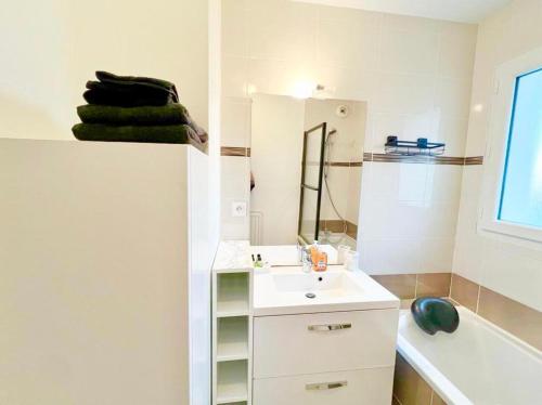 a white bathroom with a sink and a bath tub at L'atelier Chic - Wifi fibre - Parking privée - Balcon - NETFLIX in Lanester