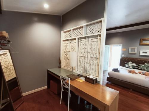 a living room with a desk and a couch at Aen Guy Boutique Hotel in Sukhothai