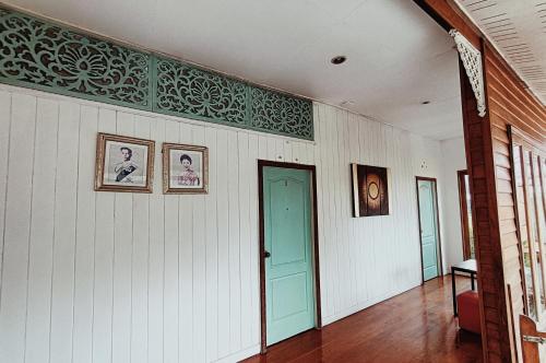 a hallway with a blue door and pictures on the wall at Aen Guy Boutique Hotel in Sukhothai