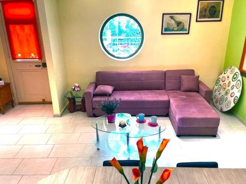 a living room with a purple couch and a glass table at Villa Simotas 4 Four in Póros Kefalonias