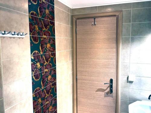 um chuveiro com uma porta de madeira na casa de banho em Villa Simotas 4 Four em Póros