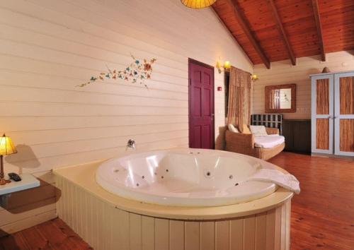 a jacuzzi tub in a room with wooden floors at לבנון ברמות in Moshav Ramot
