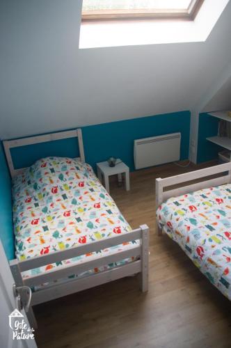 une chambre avec deux lits jumeaux et une fenêtre dans l'établissement Gîte de la Pâture, à Saint-Pierre-du-Bosguérard