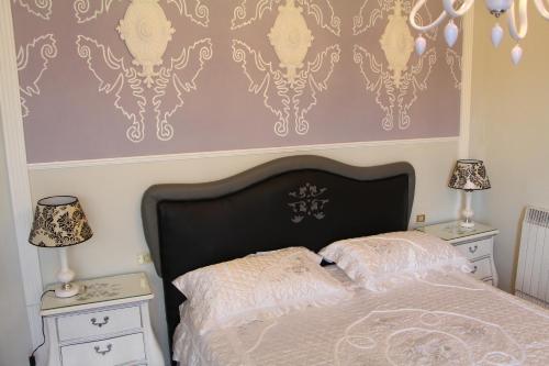 um quarto com uma cama e duas mesas de cabeceira e dois candeeiros em B&B Giorno e Notte em Pisa