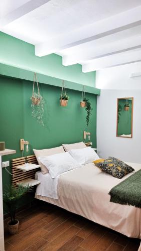 a bedroom with a large bed and a green wall at Ecorooms Ferrara in Ferrara