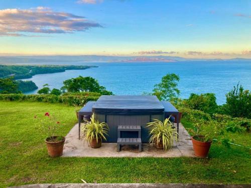 a gazebo with a bench and a view of the water at Ataalaya Farmhouse in Batangas City