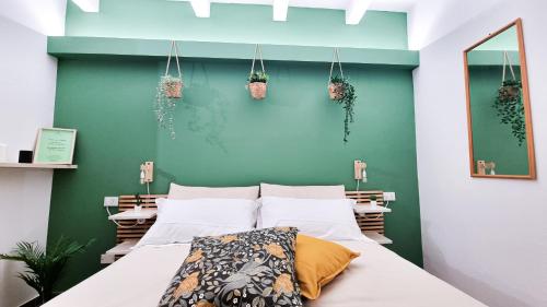 a bedroom with a bed and a green wall at Ecorooms Ferrara in Ferrara