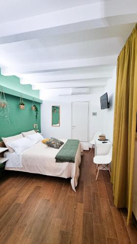 a bedroom with a large white bed and a television at Ecorooms Ferrara in Ferrara