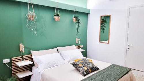 a bedroom with a bed and a green wall at Ecorooms Ferrara in Ferrara