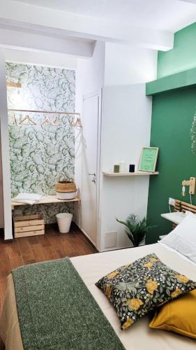 a bedroom with a bed and a green wall at Ecorooms Ferrara in Ferrara