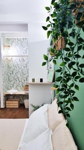 a bedroom with a green wall with a plant at Ecorooms Ferrara in Ferrara