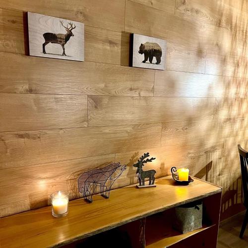 a table with two candles and two pictures on a wall at Arctic Lodges Lapland Ski In Family Studio, Wi-Fi, National Park - Lapland Villas in Pyhätunturi
