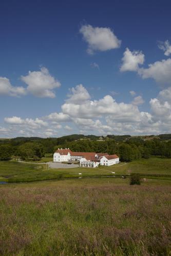 a large white house in the middle of a field at Haraldskær Sinatur Hotel & Konference in Vejle