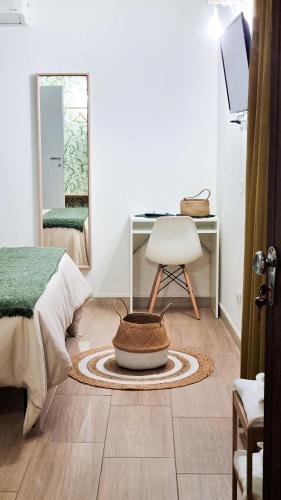 a bedroom with a bed and a chair and a mirror at Ecorooms Ferrara in Ferrara