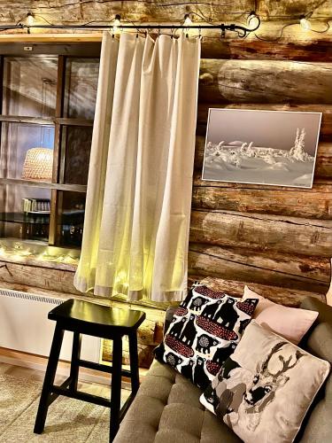 a living room with a log wall with a window at Arctic Lodges Lapland Ski In Family Studio, Wi-Fi, National Park - Lapland Villas in Pyhätunturi