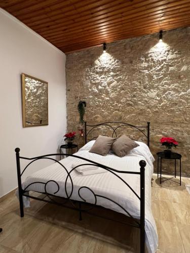 a bedroom with a bed and a stone wall at VHouse at Vouni in Vouni
