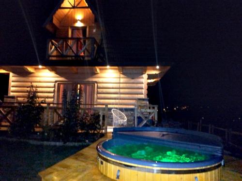 a swimming pool in front of a house at night at Zymbiańsko Chałupa 1 z balią na wyłączność in Ząb