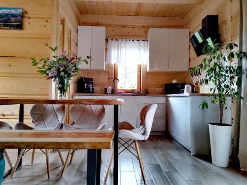 a kitchen with a table and chairs in a room at Zymbiańsko Chałupa 1 z balią na wyłączność in Ząb