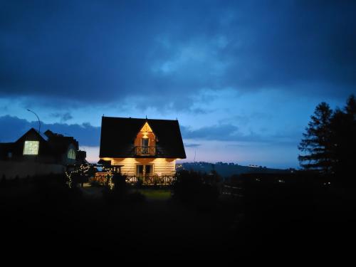 a house lit up at night with the lights on at Zymbiańsko Chałupa 1 z balią na wyłączność in Ząb