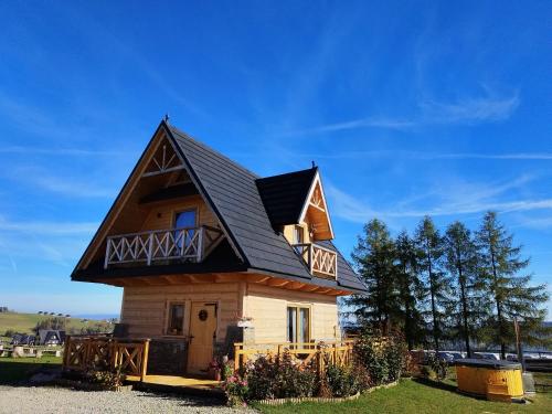 a house with a black roof on top of it at Zymbiańsko Chałupa 1 z balią na wyłączność in Ząb