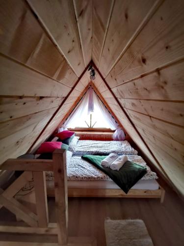 a bed in a wooden tent with a window at Zymbiańsko Chałupa 1 z balią na wyłączność in Ząb