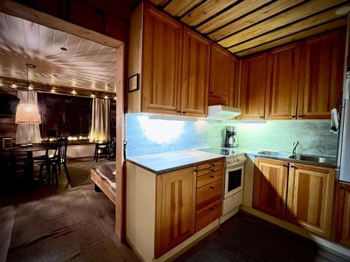 a kitchen with wooden cabinets and a table in a room at Arctic Lodges Lapland Ski In Family Studio, Wi-Fi, National Park - Lapland Villas in Pyhätunturi
