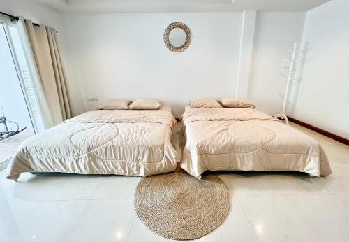 two beds sitting next to each other in a bedroom at Sky&Sea Cha-AM Beach in Cha Am