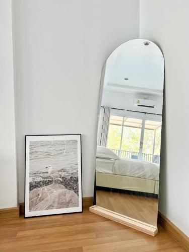 a mirror in a room with a picture on the floor at Sky&Sea Cha-AM Beach in Cha Am